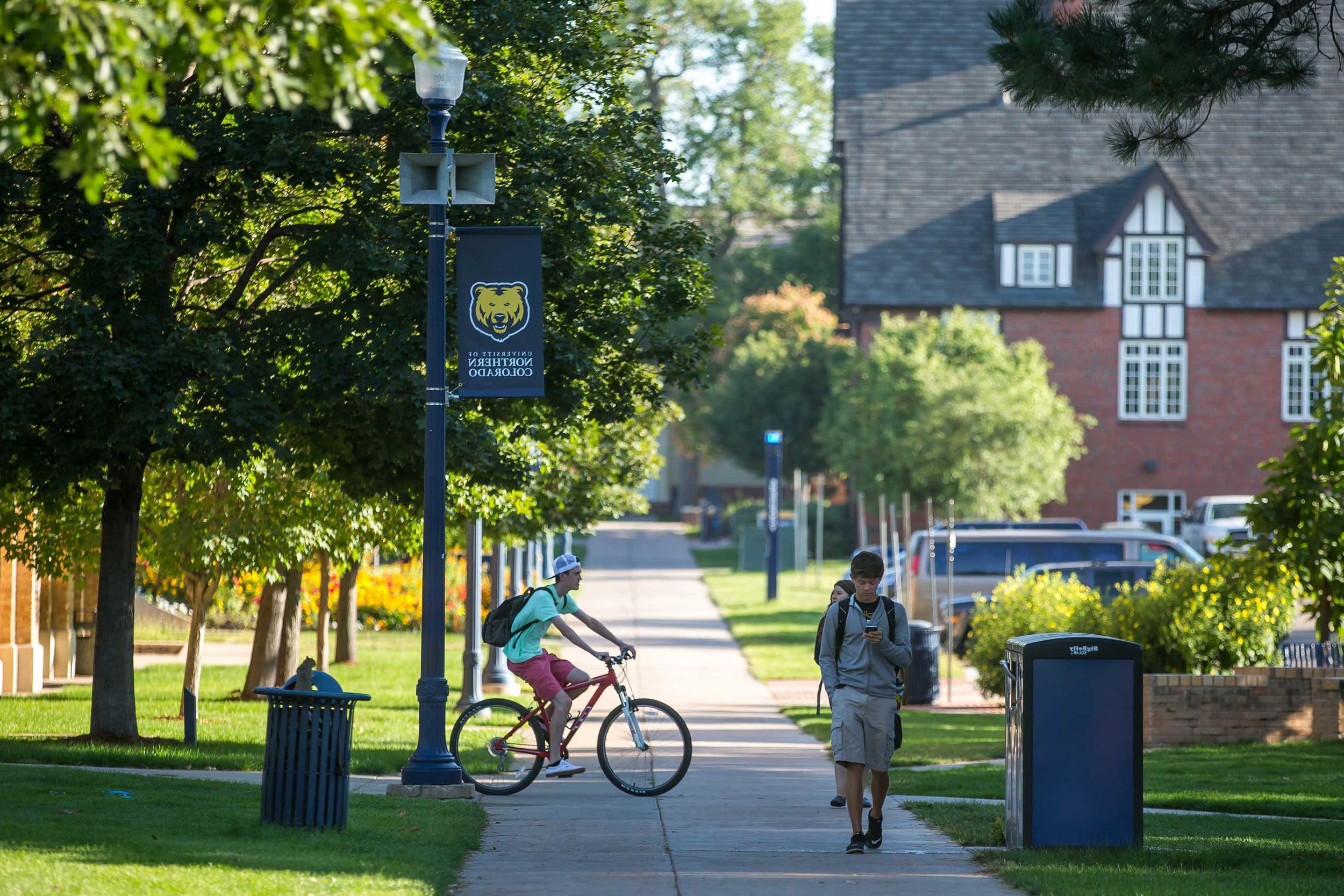 学生 riding bike on campus.